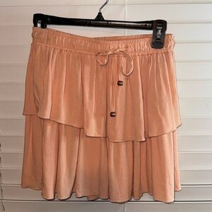 Light orange-ish blush mini skirt with wood beaded hardware on the tie part